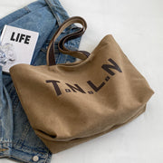 Khaki letter printed canvas tote bag with large capacity and shoulder straps for women and college students.