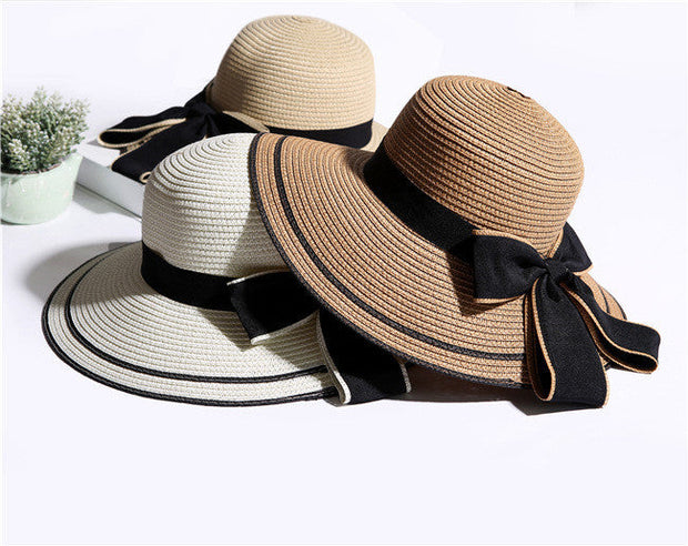 Foldable straw sun hats with wide brim and big black bow for women, beach and summer wear