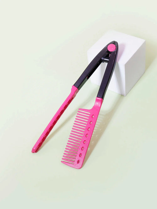 pink and black flat comb straight hair styling tool with V-shaped design on white cube background