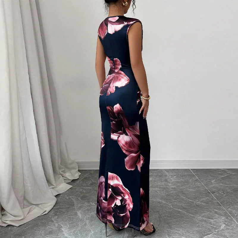 Woman wearing a sleeveless sexy bodycon maxi dress with large pink floral print, O-neck, slim fit, ankle-length, standing indoors on gray tiled floor.