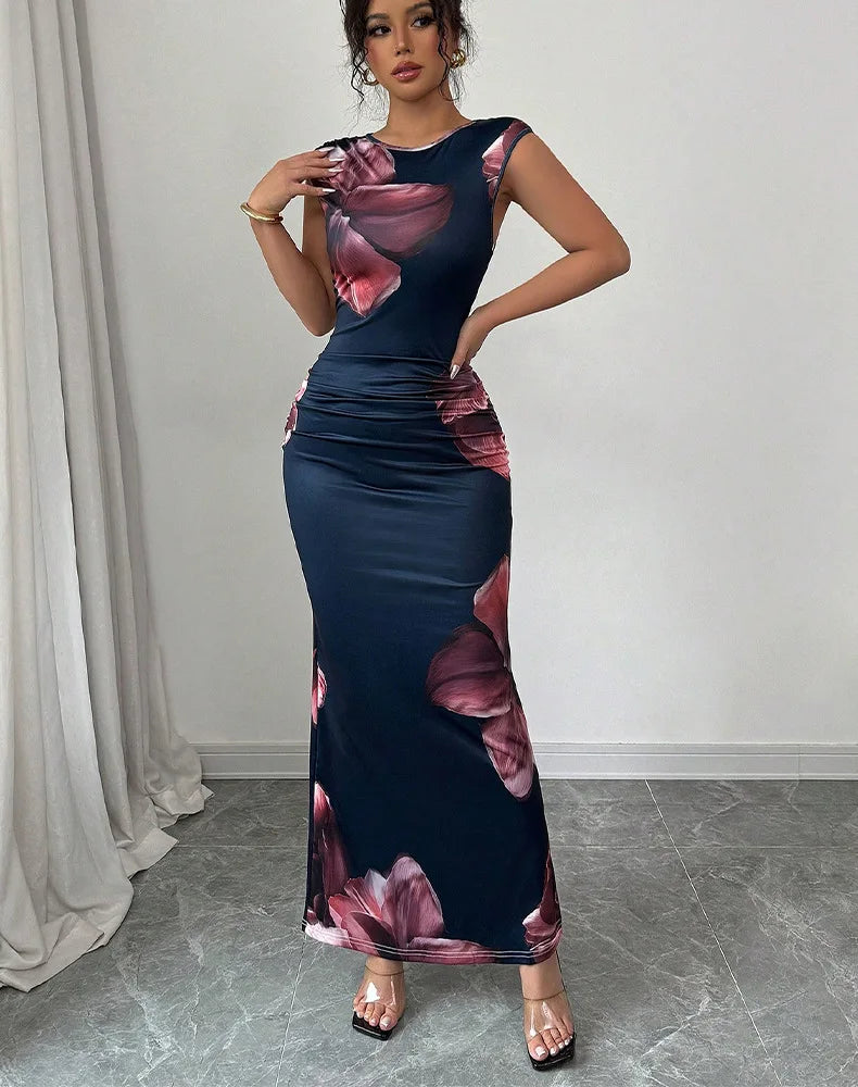 Woman wearing a sleeveless navy blue sexy bodycon maxi dress with pink floral prints and O-neck design standing indoors