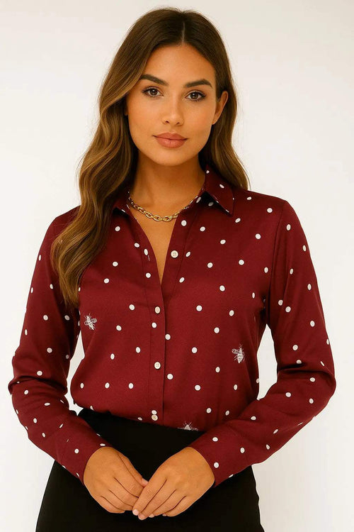 Woman wearing a wine-colored Camila "Bee" printed shirt blouse with white polka dots and bee motifs.