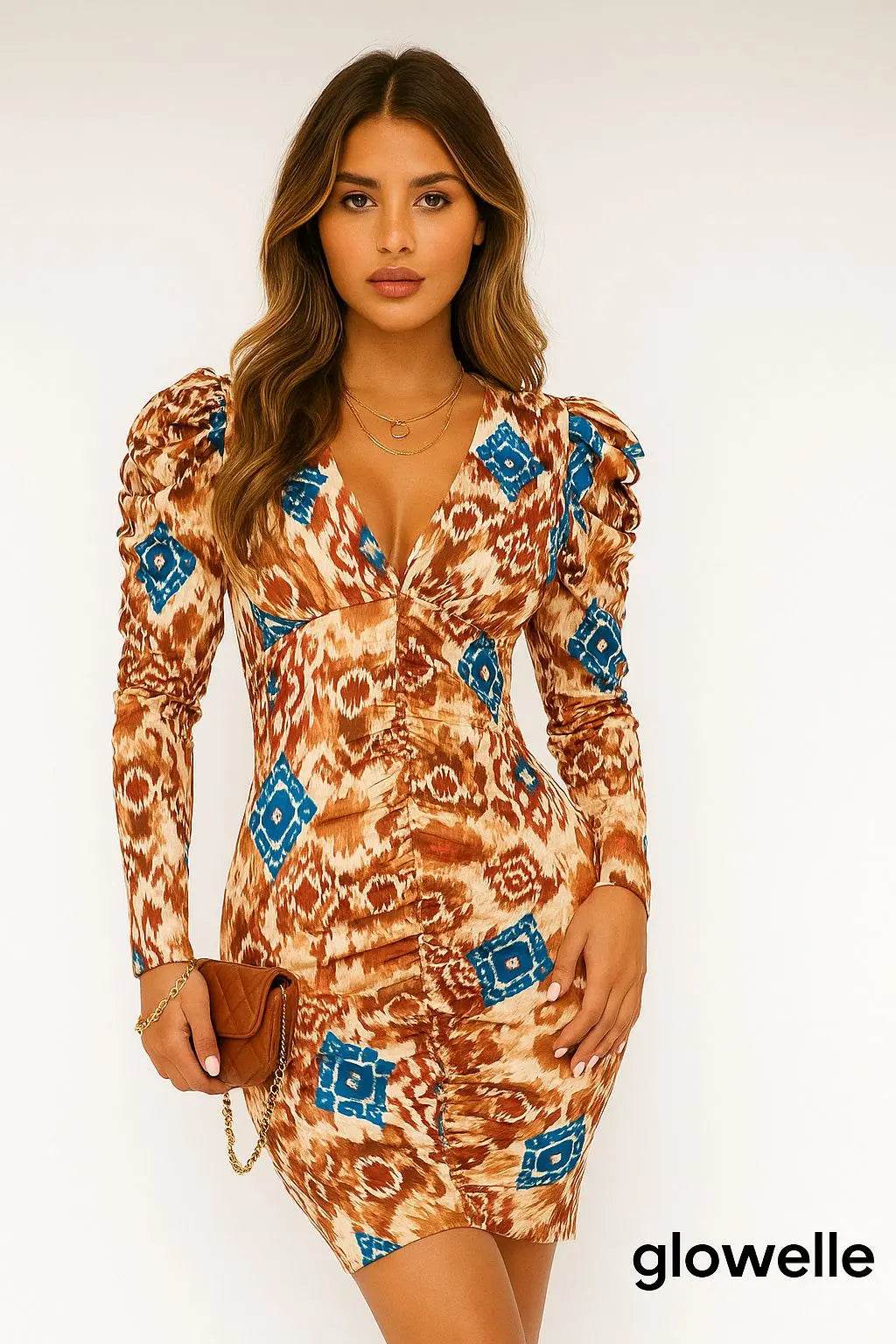Woman wearing a brown and blue abstract print bodycon ruched midaxi dress with long sleeves and puff shoulders holding a brown clutch
