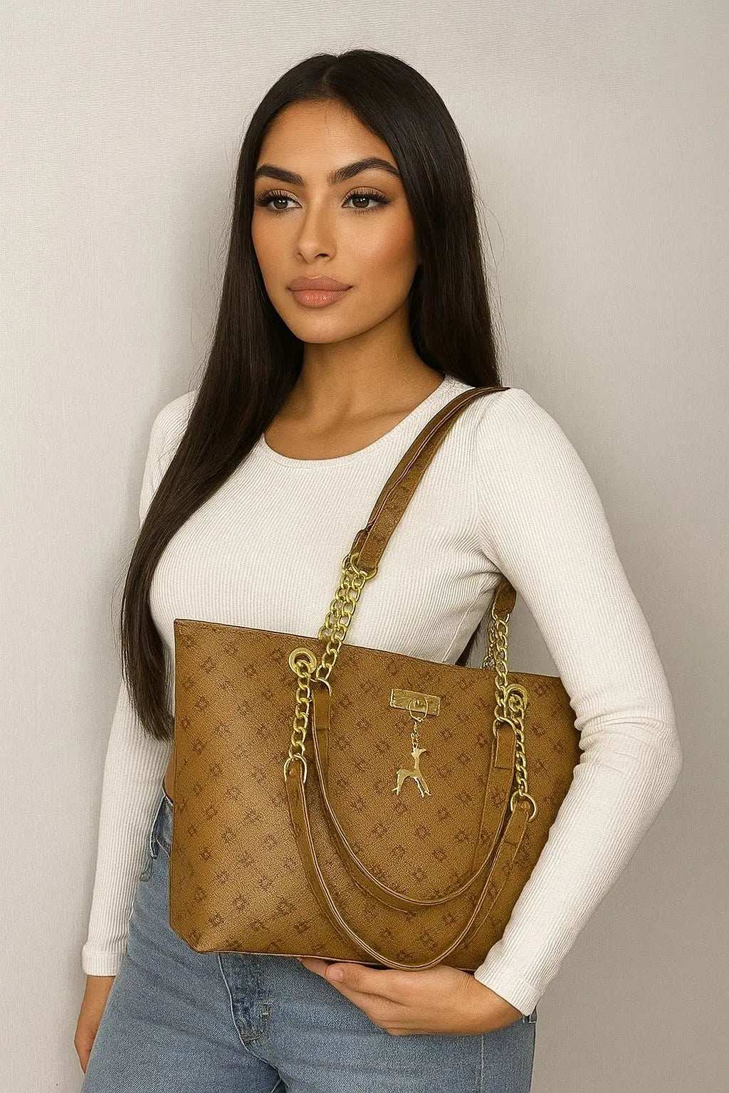 Woman wearing white top holding luxury leather shoulder bag with gold accents and chain straps
