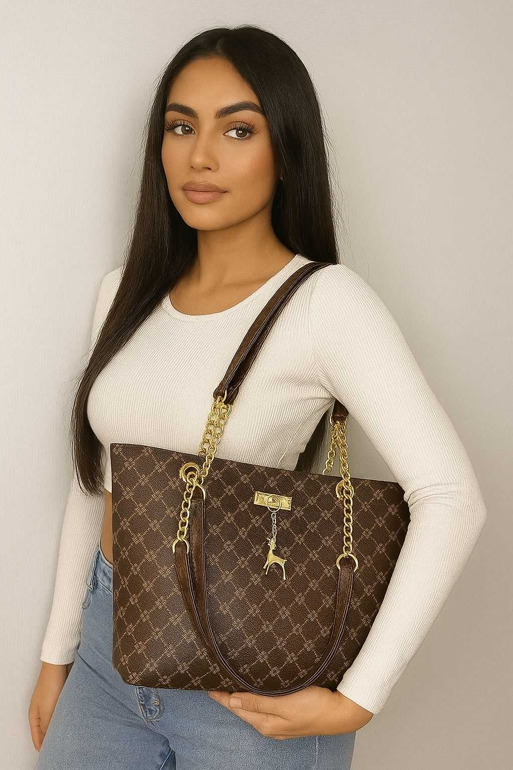 Woman holding luxury leather shoulder bag with gold chain straps and monogram pattern