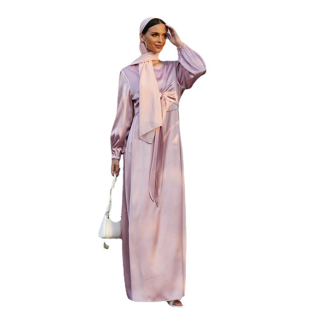 Elegant women's long satin dress in soft pink with high waist tie and long sleeves